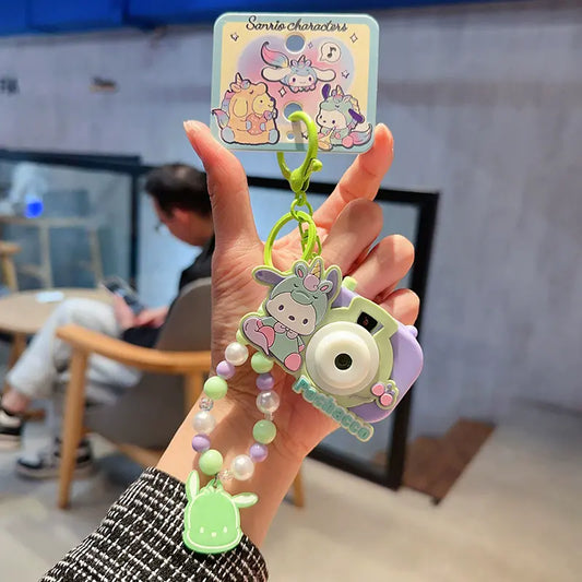Sanrio unicorn camera plush keychain, cute small accessory for bags Sanrio plush keychain with unicorn camera design, adorable accessory for backpacks Unicorn camera plush keychain by Sanrio, charming bag charm for fans